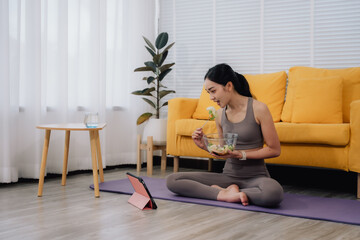 Woman Eating Salad While Watching Online Workout
