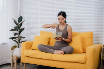 Woman Eating Salad on Sofa at Home