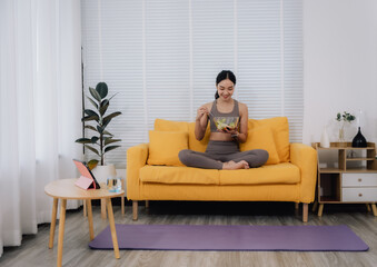 Woman Eating Salad on Sofa After Yoga