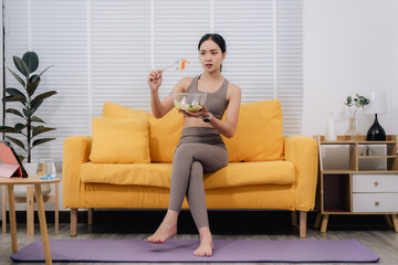 Obraz premium Woman Eating Salad After Online Yoga Class