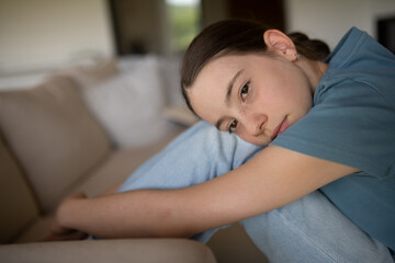 Teenage girl struggling with emotions in living room.