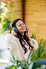 Relaxed woman enjoying free time, listening to music.