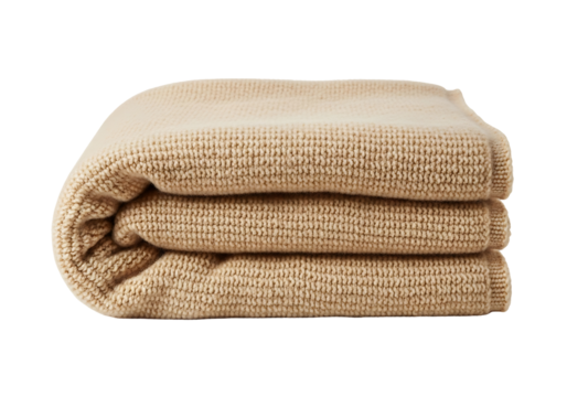A folded, beige knitted throw blanket displays a textured, repetitive pattern.