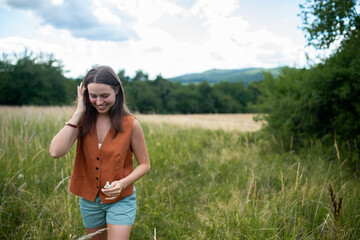 Woman connecting with nature during calming countryside stroll.