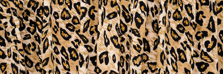 Dark black yellow soft wavy leopard spot pattern fabric background. Closeup. Wide banner. Top down...