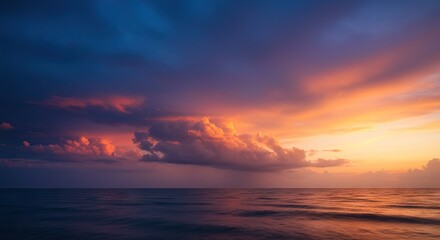 Obraz premium Sunset over ocean clouds tinted with orange and pink