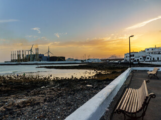 A quiet moment at sunset along the waterfront of Arrecife, Lanzarote. Empty benches face the calm...