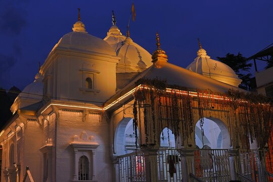The Gangotri Temple in Uttarakhand, a sacred Hindu shrine dedicated to Goddess Ganga, beautifully lit up in the evening with pilgrims visiting for darshan.