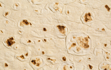 Close-up of lavash texture showing bubbles and charred spots