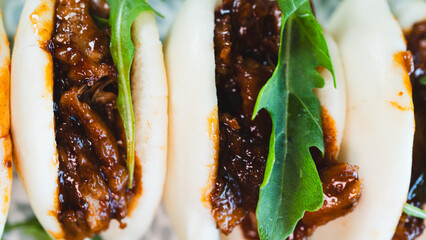 Fluffy steamed bao buns filled with succulent pulled pork, drizzled with smoky barbecue sauce and...