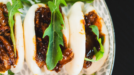Fluffy steamed bao buns filled with succulent pulled pork, drizzled with smoky barbecue sauce and...