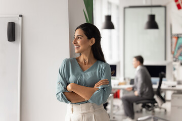 Confident Brazilian businesswoman take break stand in modern coworking office with her arms...