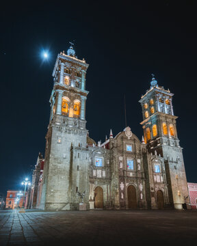 Catedral de Puebla iluminada de noche con la luna al fondo, arquitectura hist&oacute;rica y patrimonio cultural de M&eacute;xico en un ambiente nocturno espectacular.