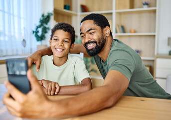 Fototapeta premium Teenage boy with his father and using phone and doing homework. Father and son bonding and having fun at home