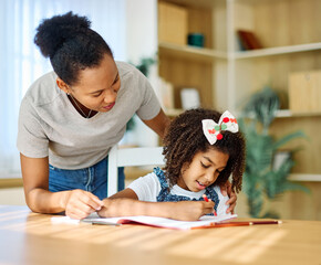 Mother and daughter doing homework at home. Mom and teenage black girl happy writing. Teen girl and...
