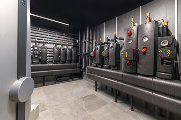 A clean, industrial space showcases several heat exchange units lined against the walls, featuring...