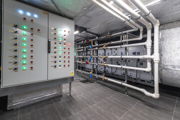 A modern industrial facility features a large control panel with numerous buttons and lights...