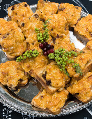Meat and cheese sandwiches, decorated with herbs and berries, on a metal plate; selective focus.