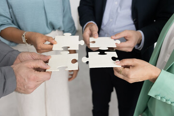Close up of four unrecognizable businesspeople professionals, staff members, colleagues holding...