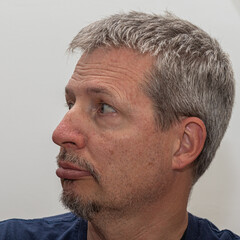 middle-aged man with a neutral facial expression, looking to the left. Useful for illustrating attention, direction, thinking process, awareness, or observational contexts in editorial 