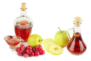 Apple cider vinegar and grape juice with fresh fruits on a white background.