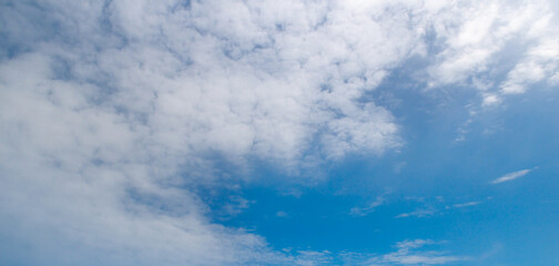 Bright blue sky with white fluffy clouds.