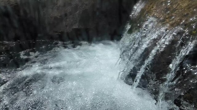 A peaceful waterfall cascading over smooth rocks, creating a tranquil atmosphere. The clear water flows gently, enhancing the calming nature of the scene, perfect for relaxation and meditation.
