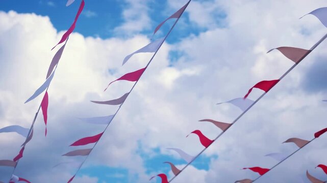 Festive ribbon of white and red triangles flags on the white clouds and blue sky background. Celebration party, holiday fair, festival decorations.