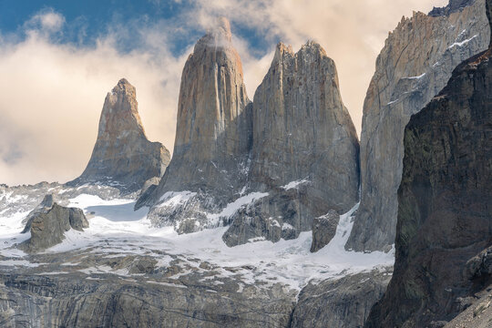 The iconic granite towers of Torres del Paine National Park in Patagonia, Chile, rising above a serene turquoise glacial lake on a clear day.