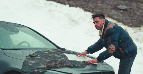 man traveling in winter with car looking at map