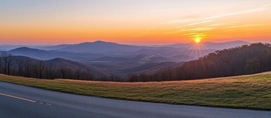 Fototapeta premium Panoramic mountain vista at sunset along a scenic road with golden light