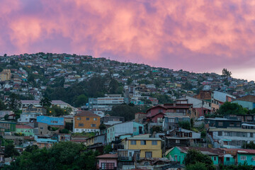 Scenic view of the sprawling, colorful hillside neighborhoods of Valparaiso, Chile, illuminated by the soft pastel colors of a twilight sky.