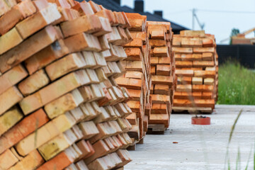 Stacked bricks ready for construction at a building site during daylight hours