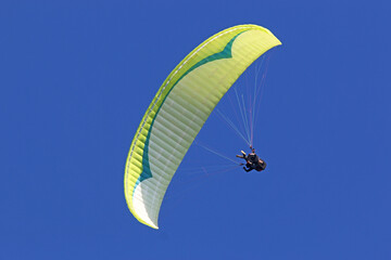 Paraglider flying in a blue sky