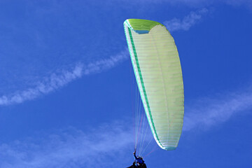 Paraglider flying in a blue sky