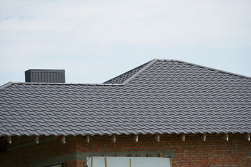 New gray roofing installation on a modern house under clear sky showing sleek design and craftsmanship