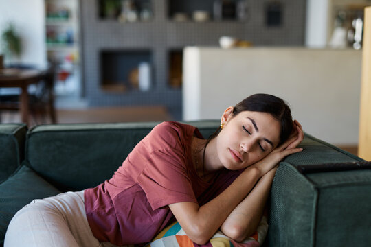 Portrait of a  young woman sleeping napping on sofa and relaxing at home
