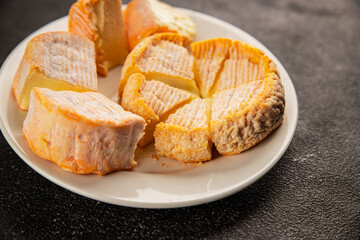 Cheese plate camembert, brie, munster french cheese tasty snack fresh delicious gourmet food background on the table rustic food top view copy space