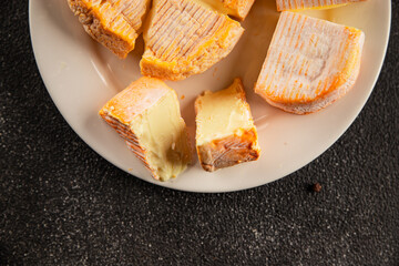 Cheese plate camembert, brie, munster french cheese tasty snack fresh delicious gourmet food background on the table rustic food top view copy space