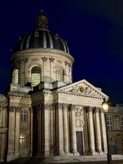Veduta notturna del Institut de France, maestoso edificio sormontato da una cupola in stile barocco, sede delle 5 accademie culturali di Francia.