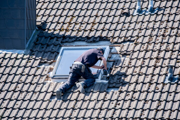 Roofers working on a roof installing a skylight