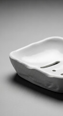 Close-up of a white soap dish with a textured surface, showcasing minimalist design and clean lines, ideal for bathroom decor or product display