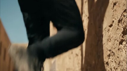 An athletic and agile man performs a daring parkour jump between two buildings in a narrow urban alley showcasing his skill and freedom in the extreme sport - Powered by Adobe