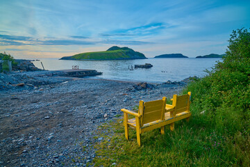 Worn Adirondack chair overlooking Tors Cove, Newfoundland Canada.