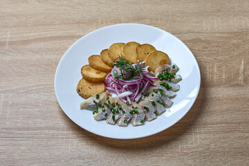 Traditional herring with potatoes and onions on plate