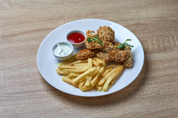 Crispy chicken strips with fries and sauces