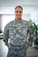 Fototapeta premium Portrait of a smiling soldier standing with hands in pockets