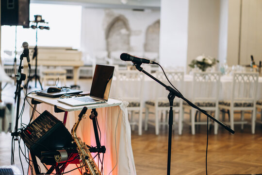 Elegant music setup with laptop, saxophone, and microphones prepared for a live performance in a sophisticated event venue wedding DJ musician 