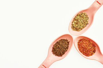 Three spoons with dried various herbs, spices
