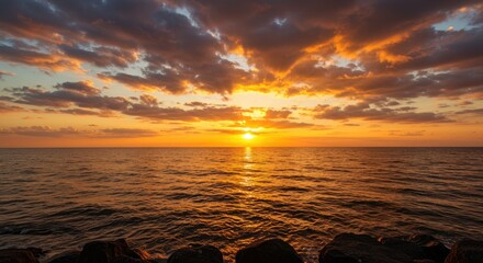 Dramatic sunset over the ocean with sun rays breaking through clouds